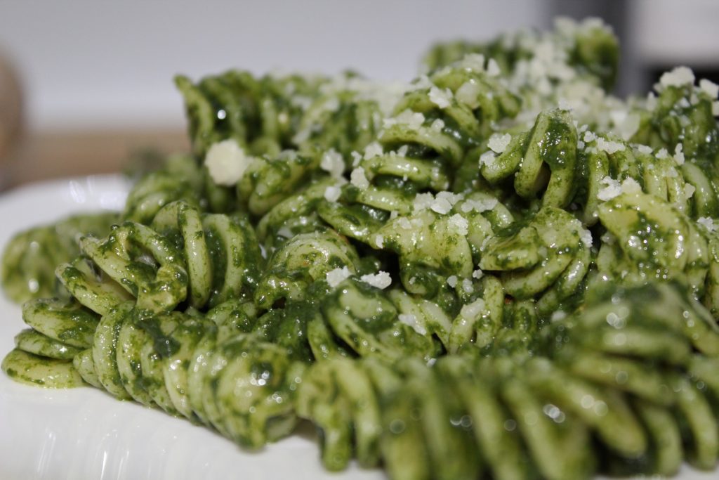Fusilli with pesto sprinkled with Parmesan cheese