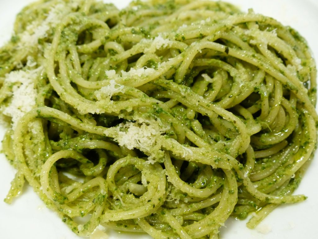 Spaghetti with a pesto sauce topped with grated parmesan