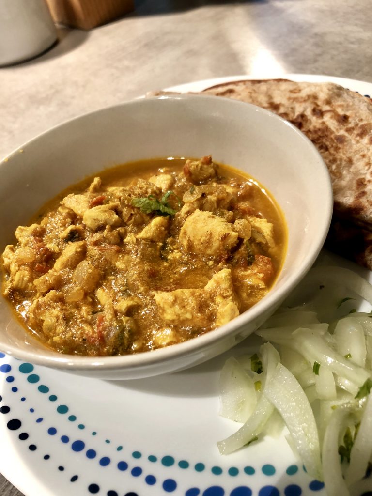 Chicken curry in a bowl served with rotis