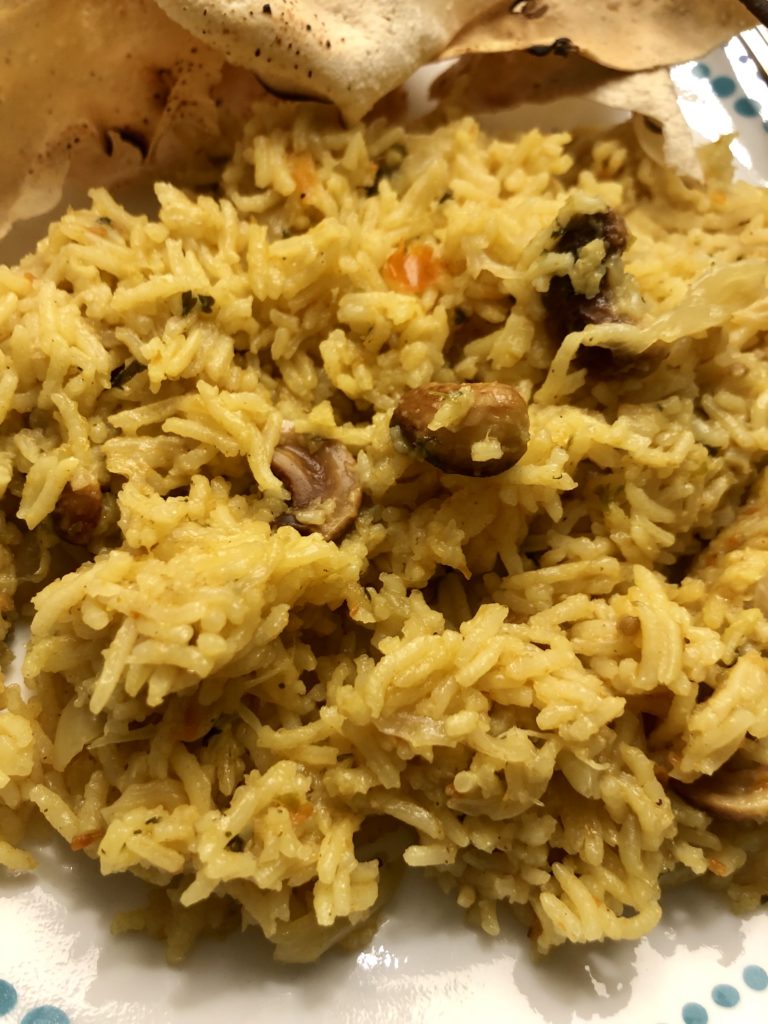 Yellow coloured tomato coriander spiced rice on a plate