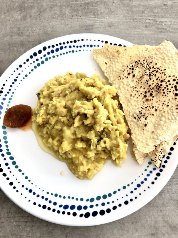 Dal khichdi on a white plate with poppadoms and pickle