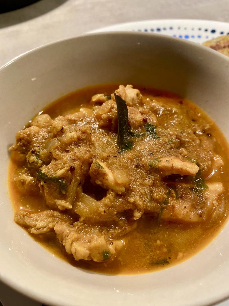 Bowl with chicken ka Salan - a curry made with coconut, peanuts, sesame and tamarind