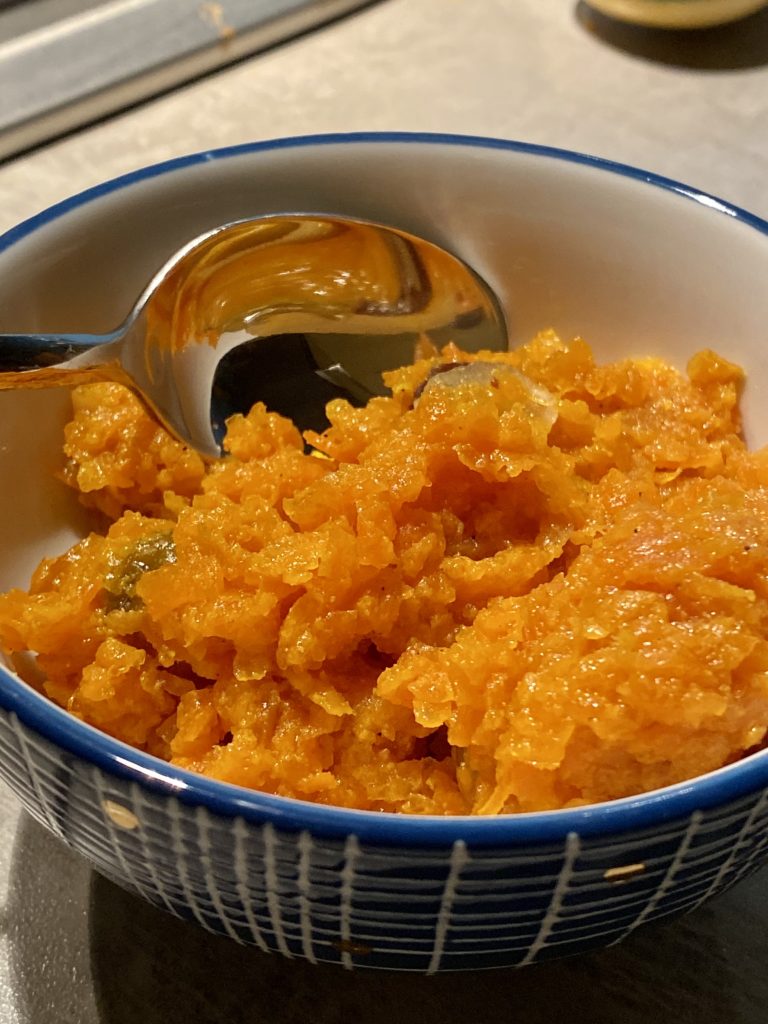 Carrot halwa close up in a bowl with a spoon.