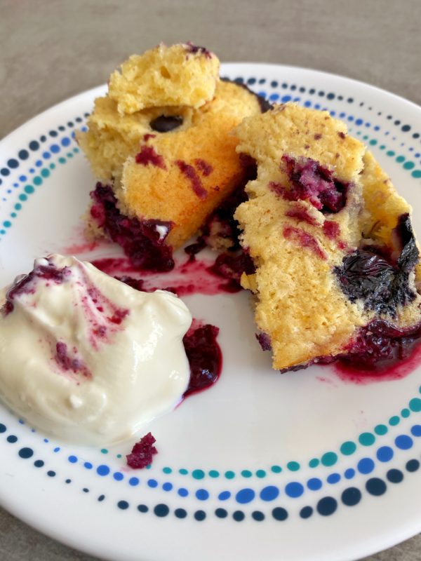 Blueberry and coconut cardamom pudding served on a dish with a dollop of creme fraiche